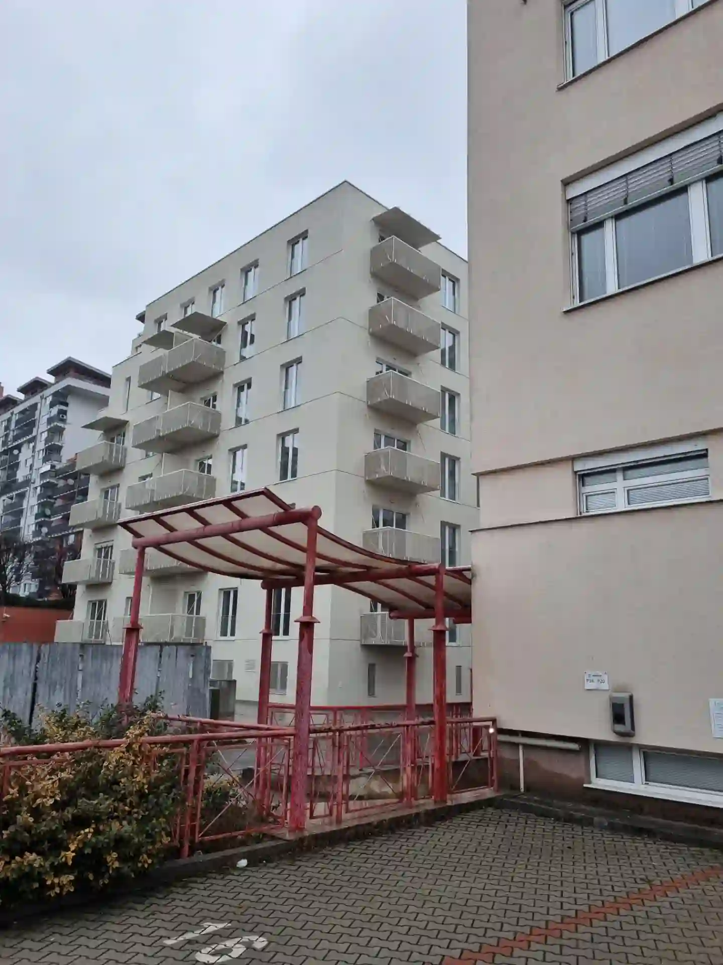 Celkový pohled na bytový dům se závěsnými balkony z přilehlého dvora