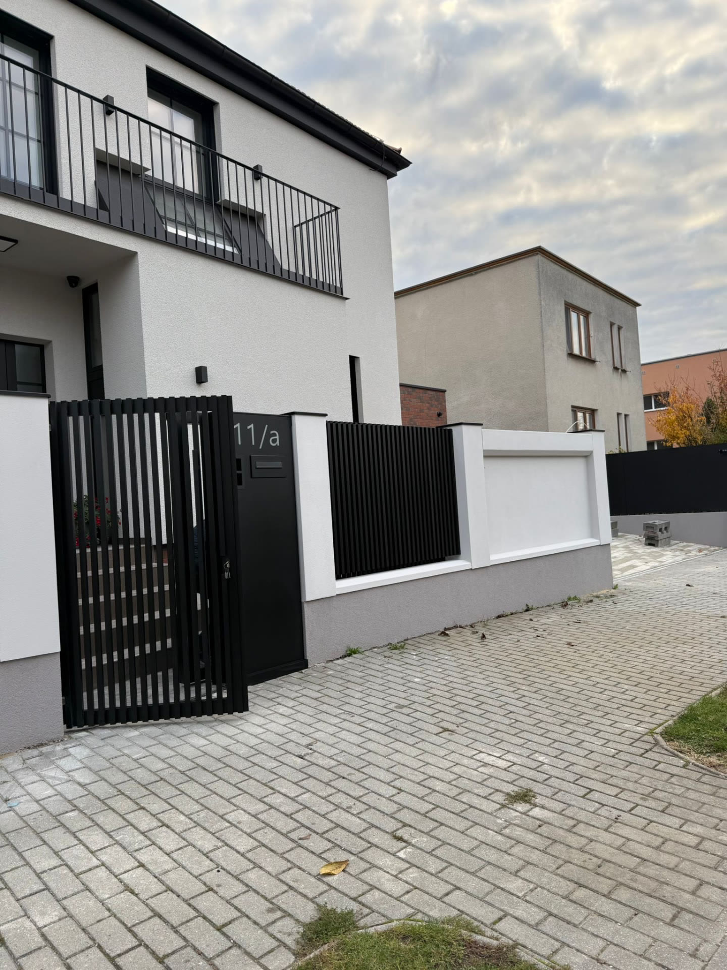 Černá lamelová branka s poštovní schránkou a domovovým číslem 11/a