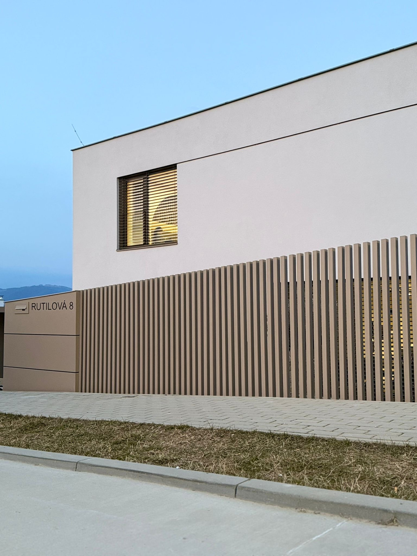 Béžový lamel plot před moderním rodinným dům