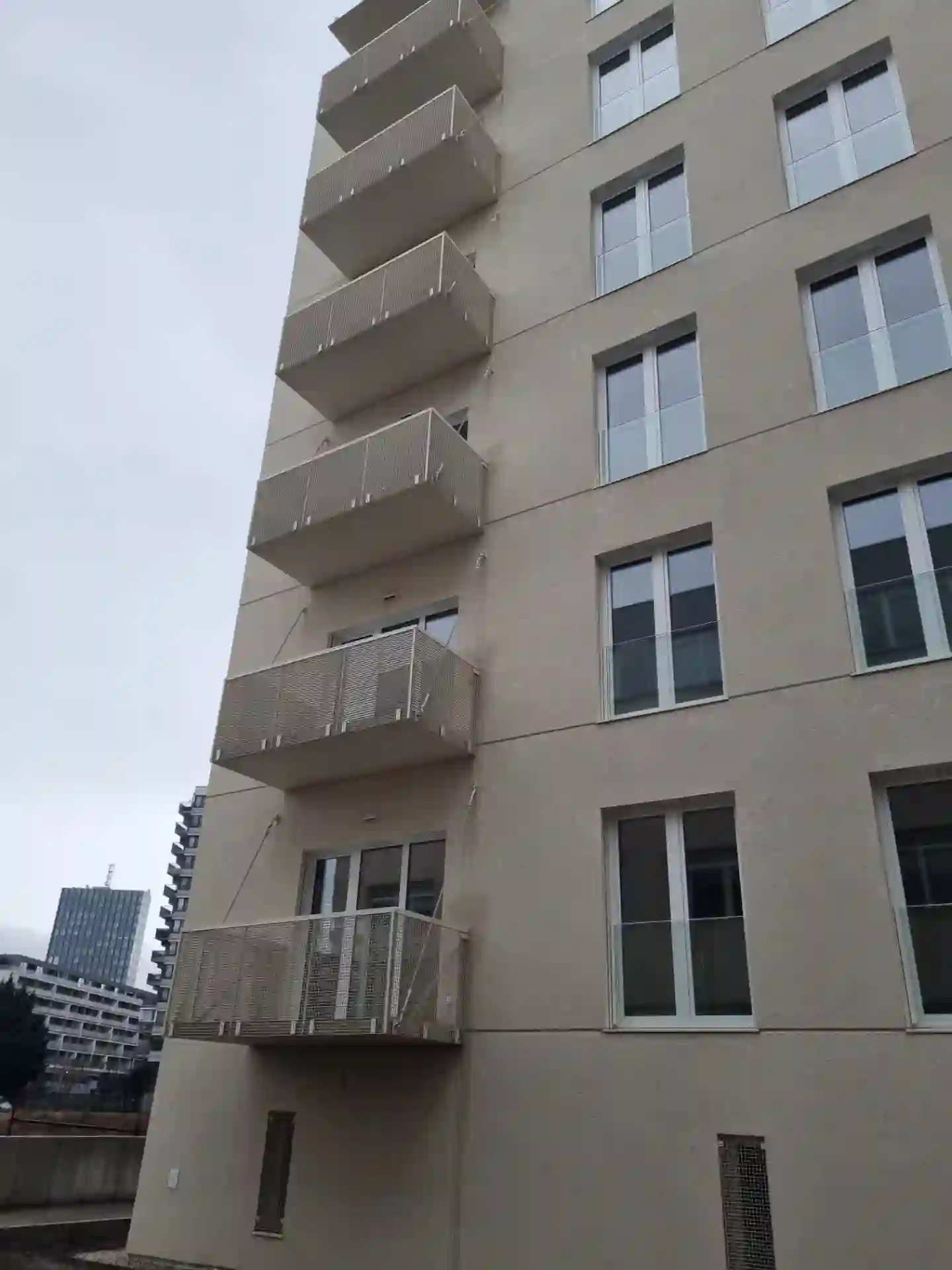 Řada závěsných balkónů s těhokovovým zábradl na rohu bytového domu